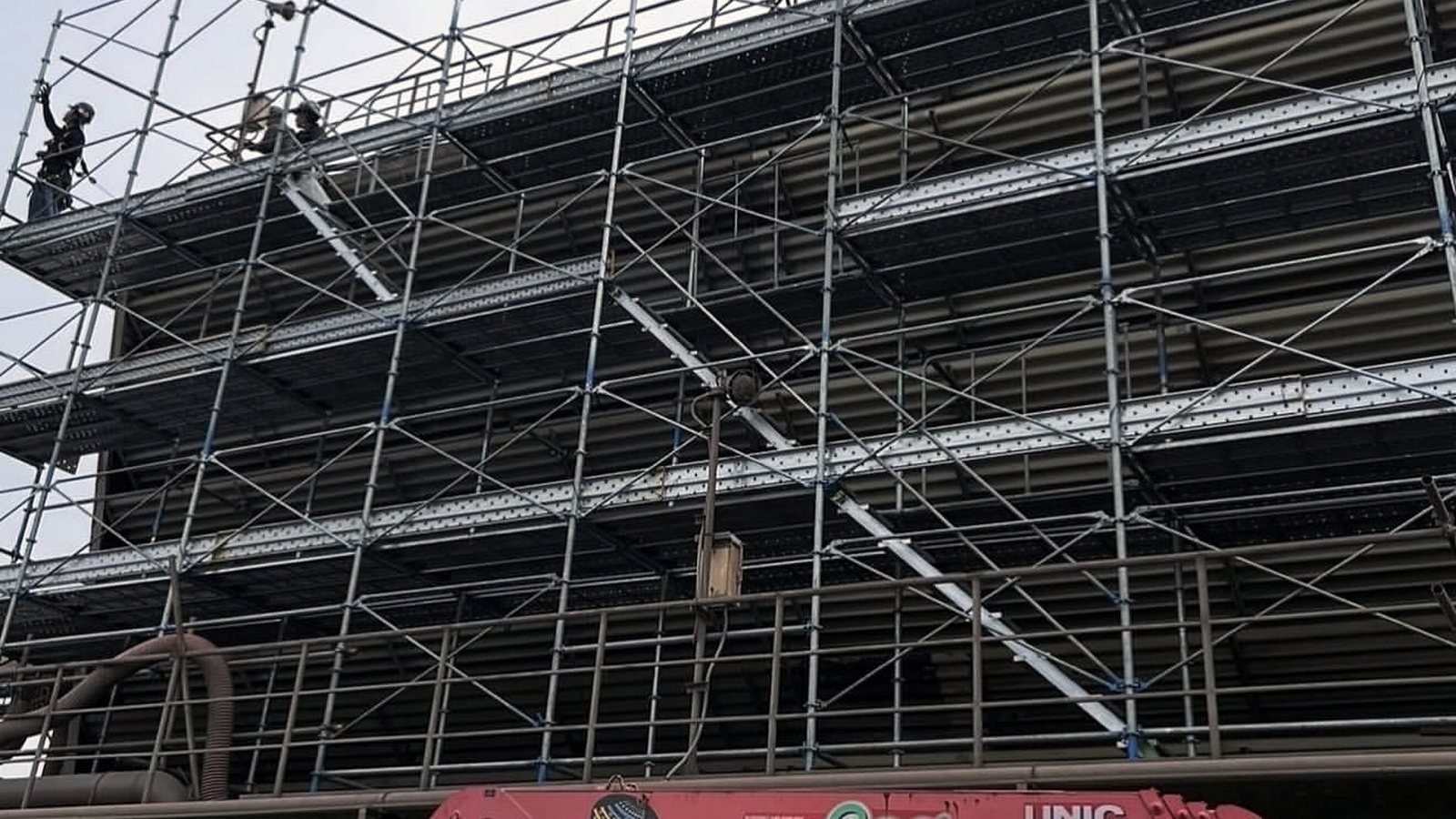 建物を覆うように高く組み上げた多層の足場
